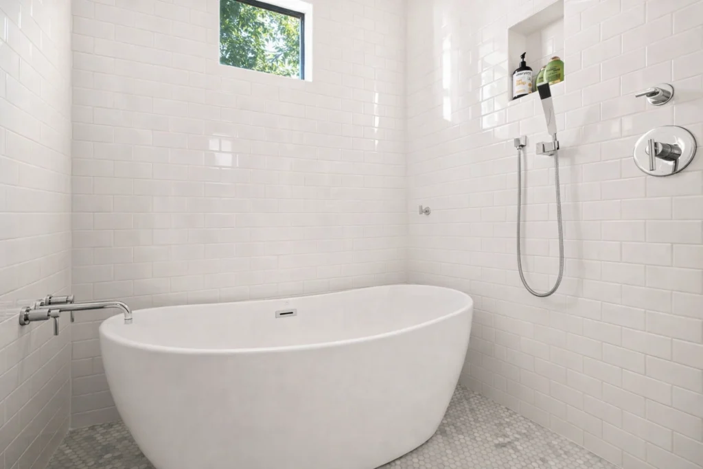 Minimalist bathroom with freestanding soaking tub and white tile walls