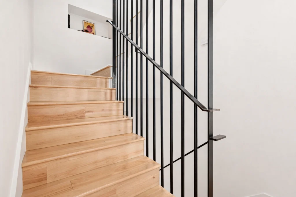 Modern staircase detail with custom black railing and oak treads