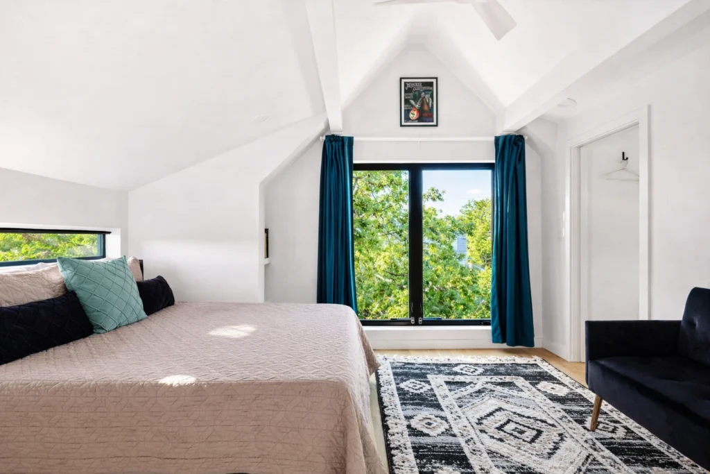 Bright contemporary bedroom with vaulted ceilings and black-framed windows