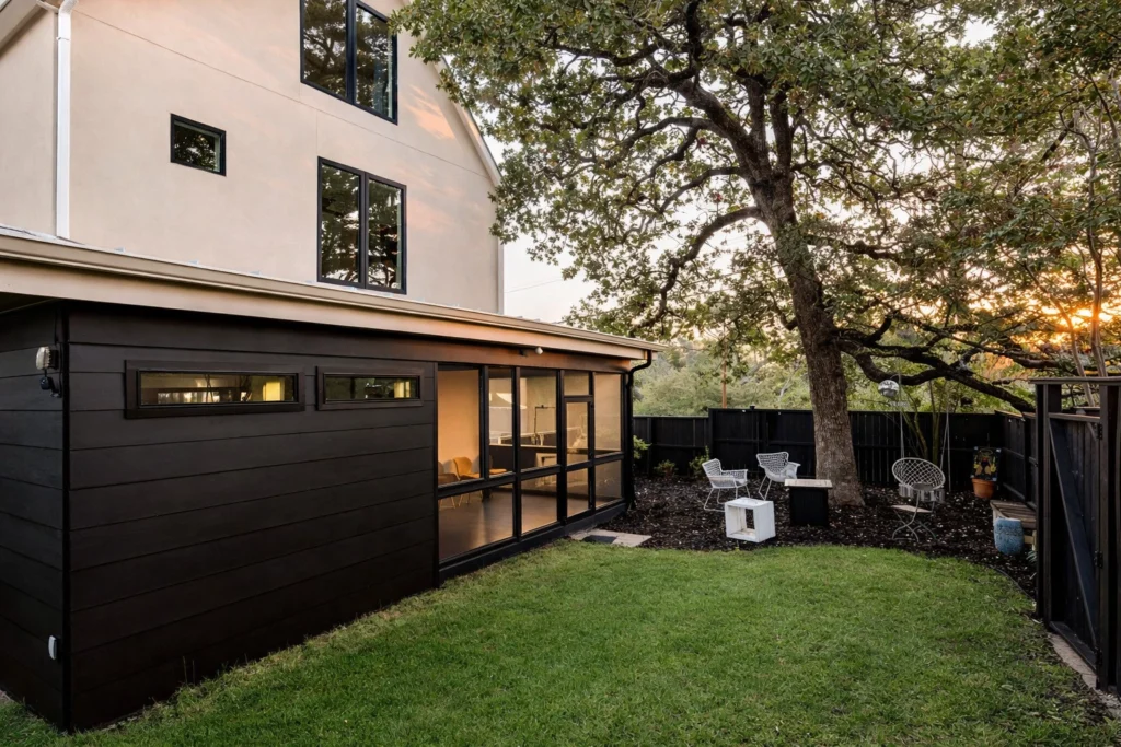 Modern home exterior with screened patio and black garage door