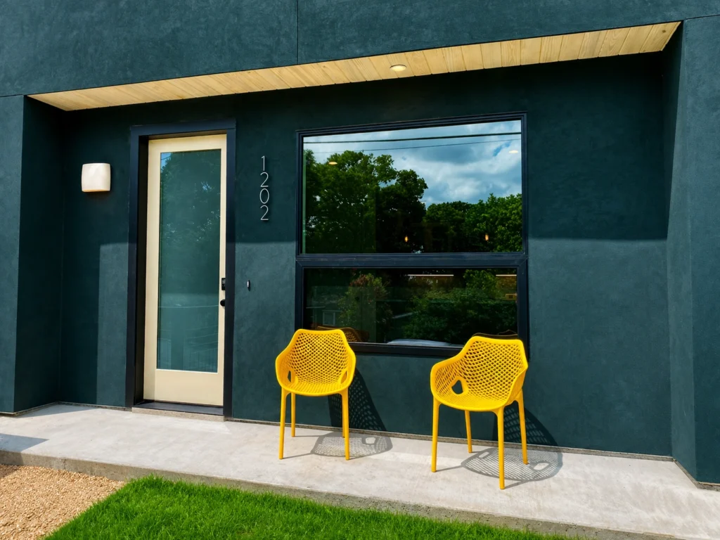 Contemporary home entry with yellow outdoor chairs and black-framed windows