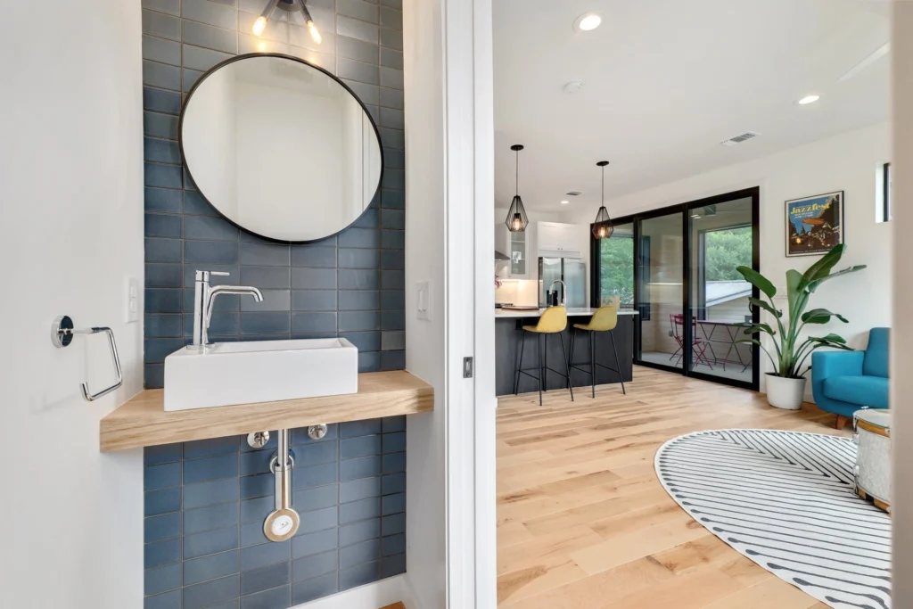 Modern powder bathroom with floating vanity and blue tile accent wall