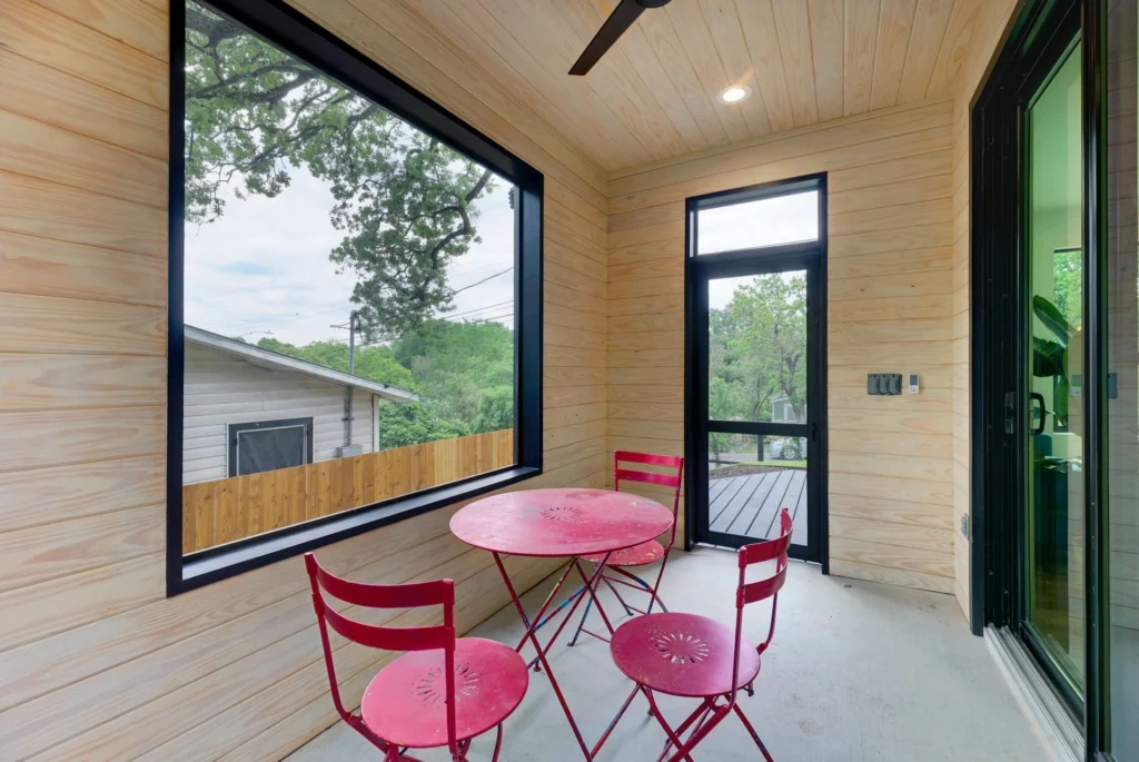 Screened balcony with natural wood walls and modern outdoor seating