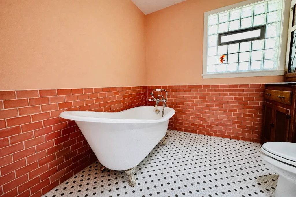 Vintage-inspired bathroom remodel with coral subway tile and freestanding tub