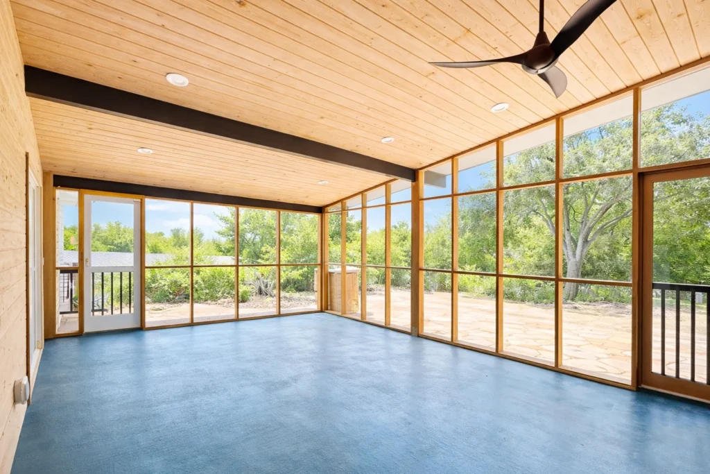 Screened outdoor living space with natural wood ceiling and panoramic windows