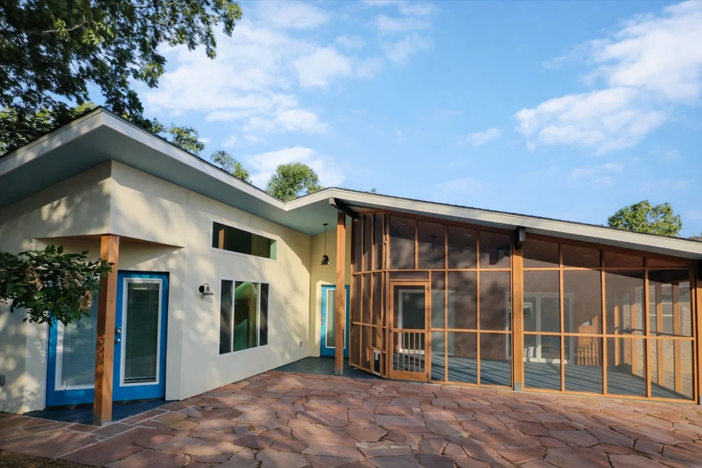 Contemporary outdoor patio with screened-in living space and natural landscaping