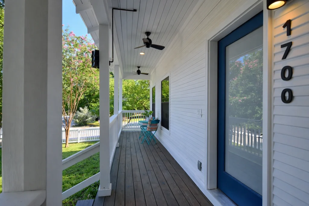 Modern farmhouse front porch with blue entry door and covered outdoor seating
