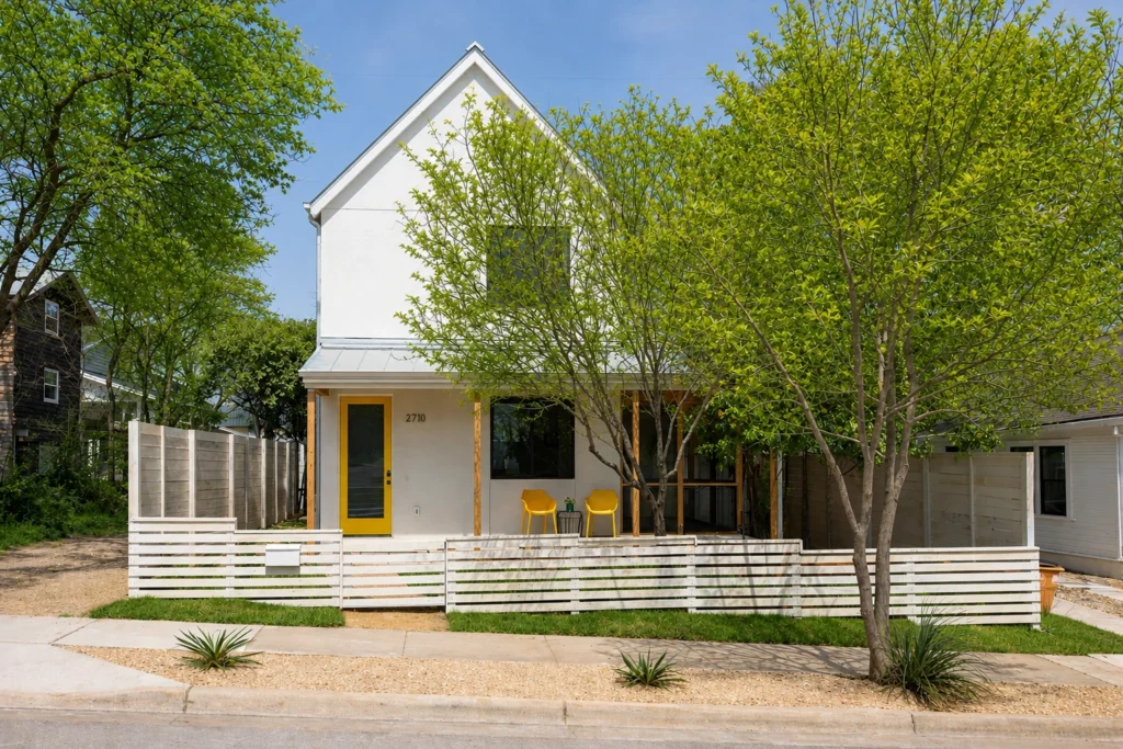 Modern white custom home exterior with yellow front door and covered porch