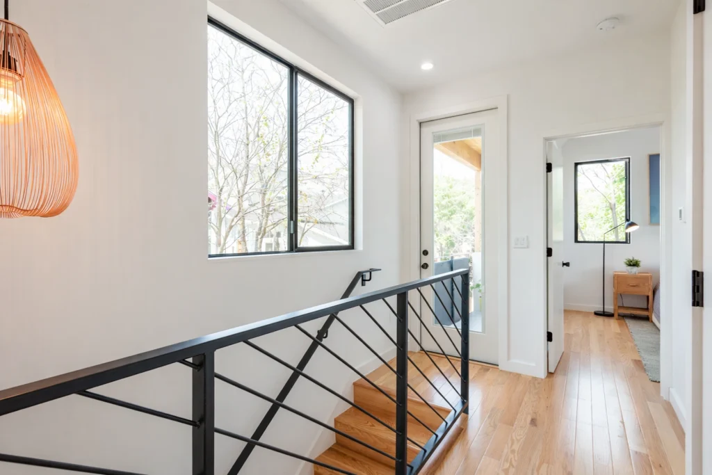 Modern staircase with black metal railing and natural wood flooring
