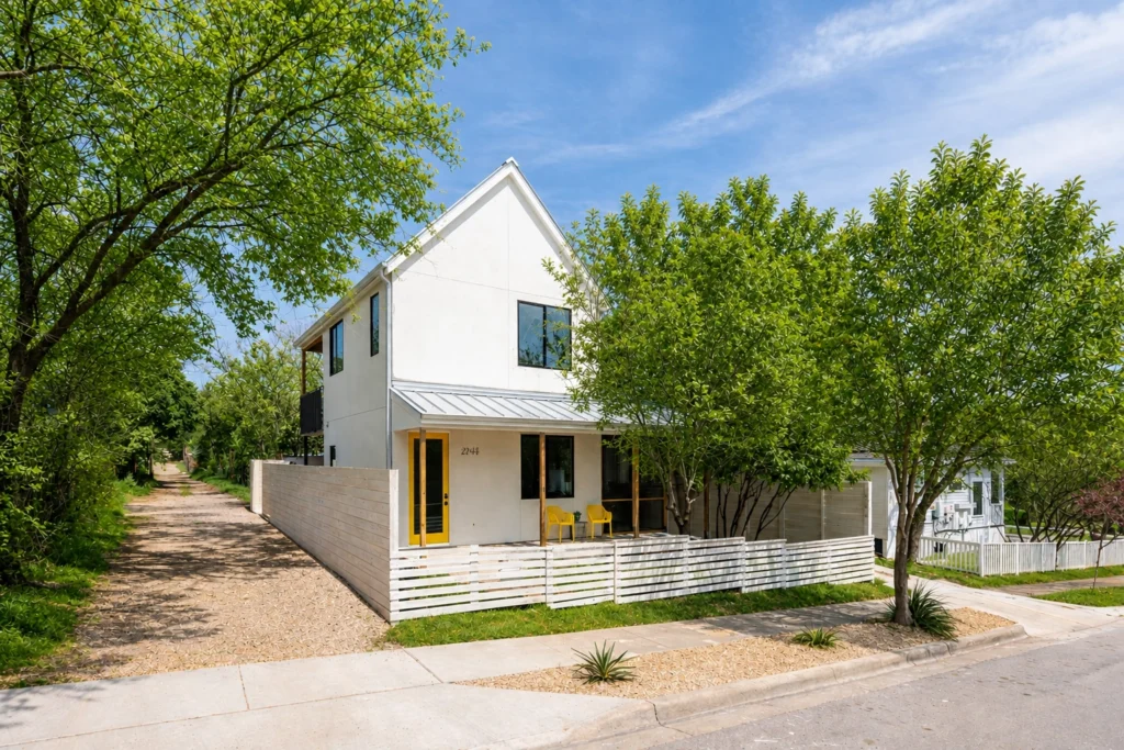 Luxury custom home exterior with yellow front door and covered porch built by Bwell Best Constraction