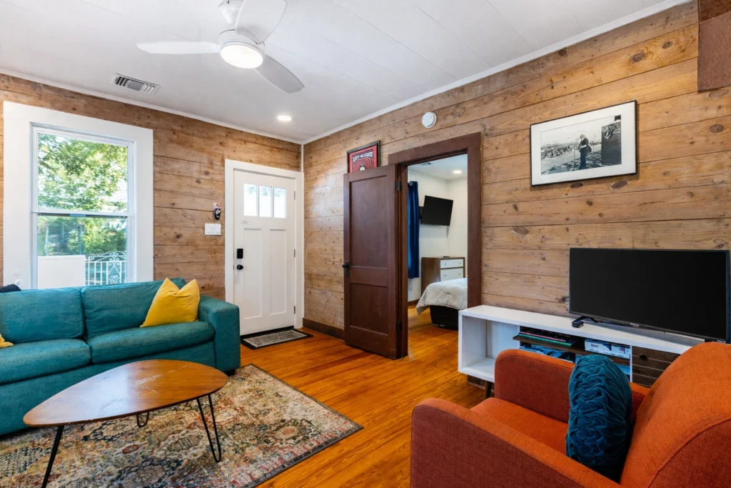Open-concept cottage interior with loft ladder and colorful furniture