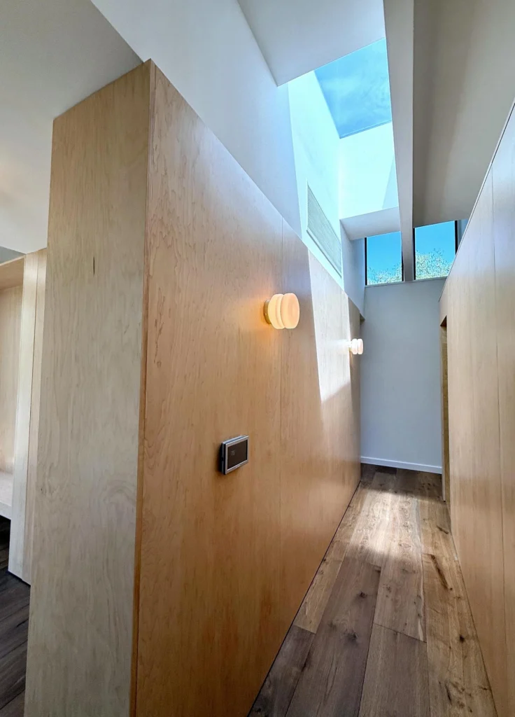 Modern interior hallway with skylights and custom wood wall paneling