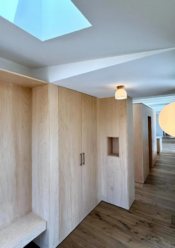 Modern custom millwork hallway with skylight and natural wood textures