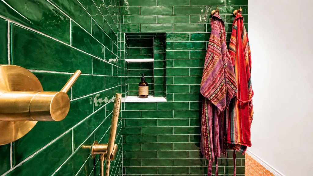 Vibrant green tiled bathroom with towels
