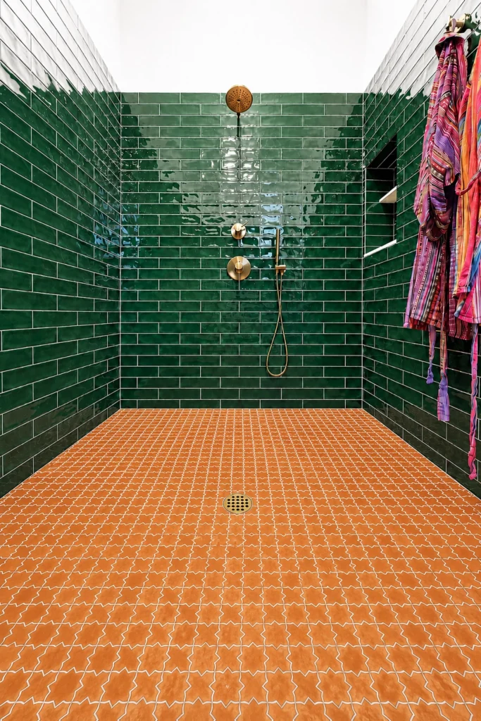 Green tiled shower with patterned floor